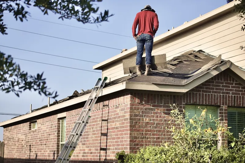 Professional roofer working on a residential roof in Handy